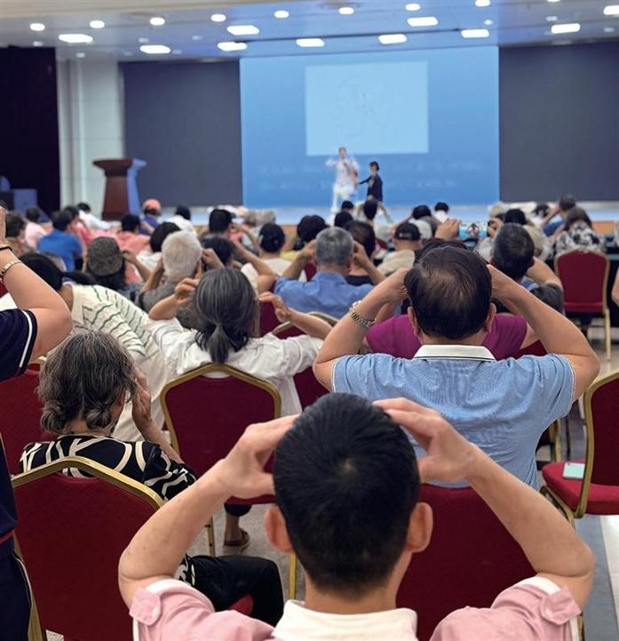 活动现场,市民们跟着浙江省中山医院心血管科护士做降压操。 记者 金晶 摄